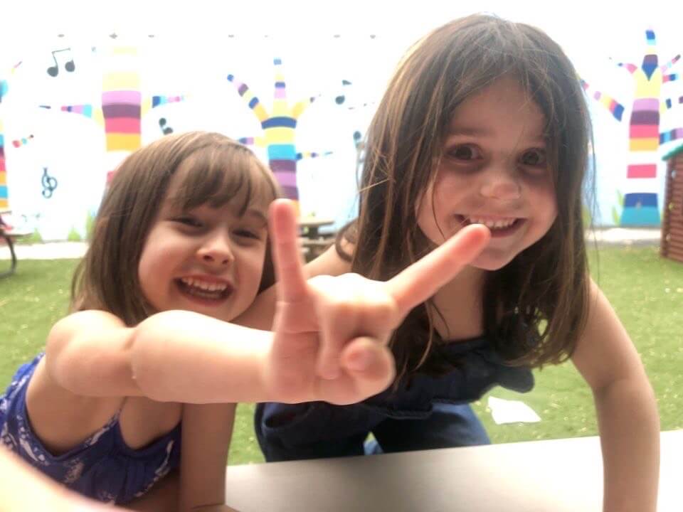 Two girls having fun and smiling. Visit our preschool education center in Owings Mills, Maryland.
