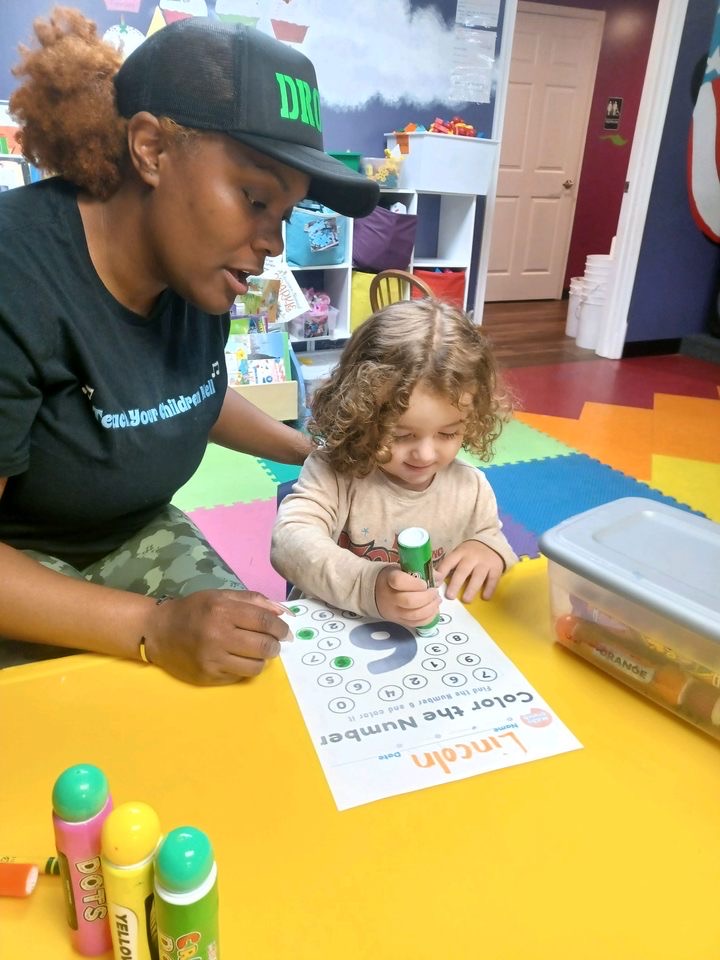 Teacher and child doing number coloring activity.