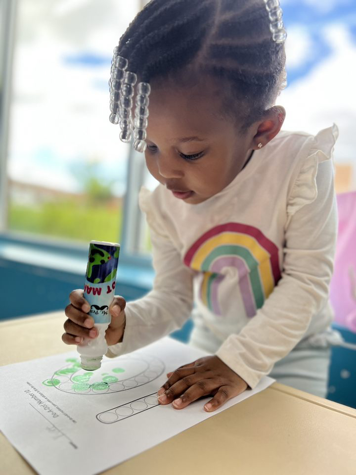 Child coloring with marker on paper.