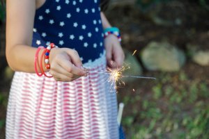 Girl Hold Sparkler while Watching Fireworks