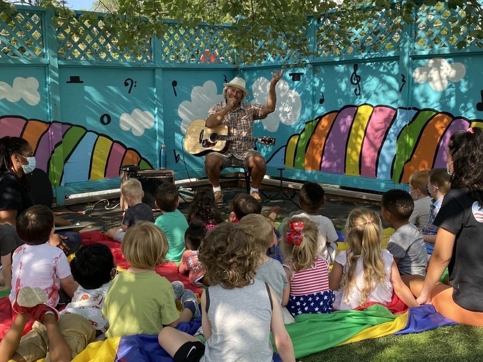 Children sitting in front of a musician performing on stage. Drool of Rock, a Cockeysville-based preschool center, has been nurturing lifelong relationships and building children's confidence since 2013. Catering to children aged 6 weeks to 5 years, the center offers a unique music program in partnership with Lutherville Rock School and boasts a secure, engaging facility complete with a turf-filled courtyard for daily playtime.
